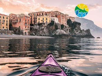 A group of adventurers on a guided kayak tour Amalfi Coast exploring hidden sea caves and turquoise waters.
